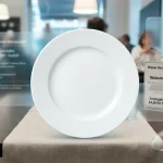 Порожня біла керамічна тарілка на дерев'яному столі в сучасному європейському ресторані із елементами гласморфізму